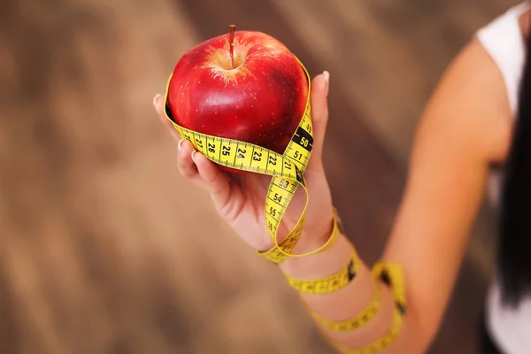 Närbild på att mäta apple i kaukasiska kvinnas händer. — Stockfoto