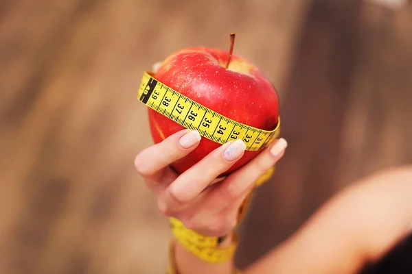 Primer plano sobre la medición de la manzana en las manos de la mujer caucásica . —  Fotos de Stock