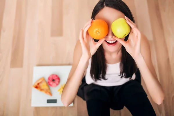 Mujer deportiva con escamas y manzana verde y naranja —  Fotos de Stock