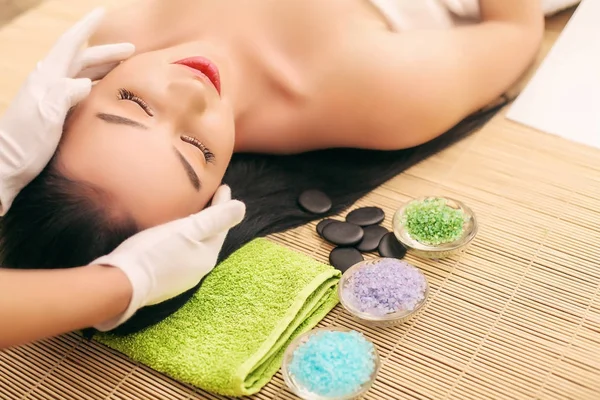 Primer plano de una mujer joven recibiendo tratamiento de spa en el salón de belleza. masaje facial spa. Tratamiento de belleza facial. salón de spa. — Foto de Stock