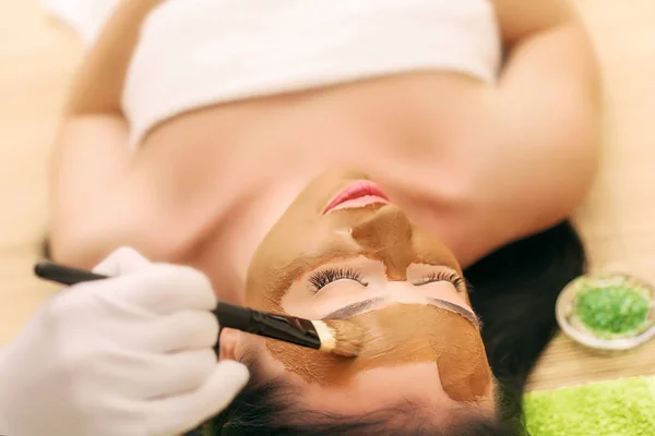 Wellnessmaske. Frau im Wellnesssalon. Gesichtsmaske. Gesichtsmaske aus Ton. — Stockfoto