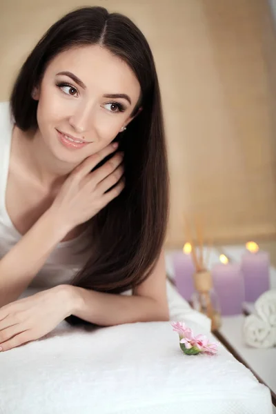 Piękna młoda kobieta leżąca na stole do masażu w salonie spa — Zdjęcie stockowe