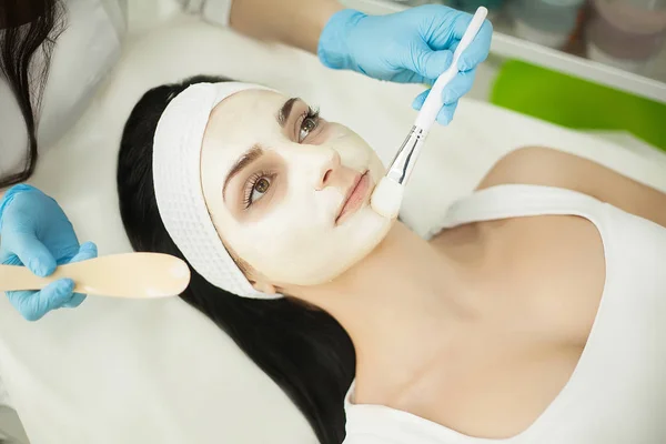 Vrouw liggend op een massagetafel in kuuroord terwijl gezichtsmasker is — Stockfoto
