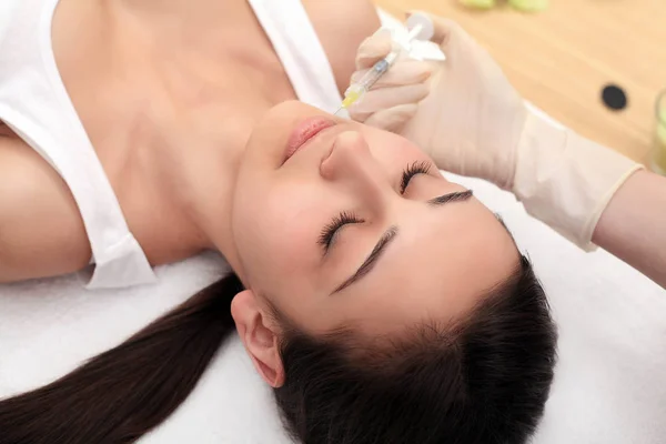Vrouw krijgt injectie in haar gezicht. Schoonheid vrouw geven van injecties — Stockfoto