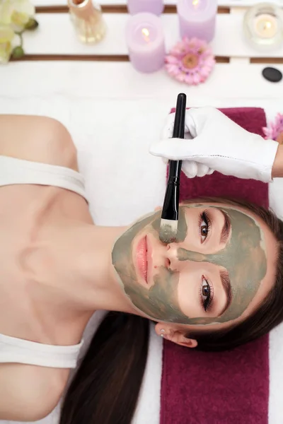 Spabehandlingar för ung kvinna att ha ansiktsmask på skönhetssalong - — Stockfoto