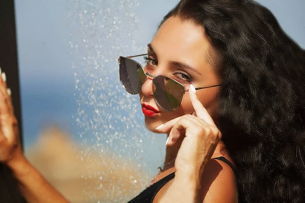 Belle femme sexy prenant une douche sur la plage . — Photo