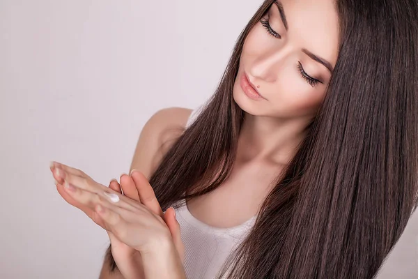 Gesichtsbehandlung. Frau im Schönheitssalon. Anwendung kosmetischer Creme. eine schöne junge Frau, die Gesichtsfeuchtigkeitscreme aufträgt. Pflegen des Gesichts und der Hände — Stockfoto