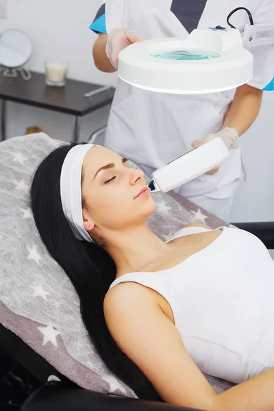 Cosmetology. Ultrasonic face cleaning, peeling, in a beauty salon. Beautiful Woman Receiving Facial Skin Ultrasound Cavitation. — Stock Photo, Image