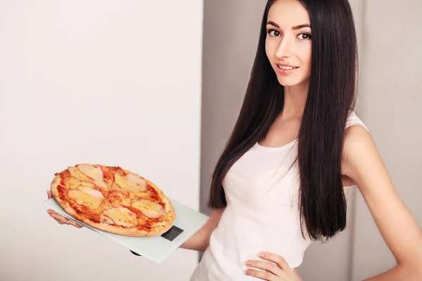 Diet And Fast Food Concept. Femme en surpoids debout sur l'échelle de pesée tenant la pizza. Malsaine malbouffe. Régime, mode de vie. Perte de poids. Obésité — Photo