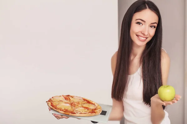 ダイエット。スケールでピザを保持している若い女性。健康的な食事の概念 — ストック写真