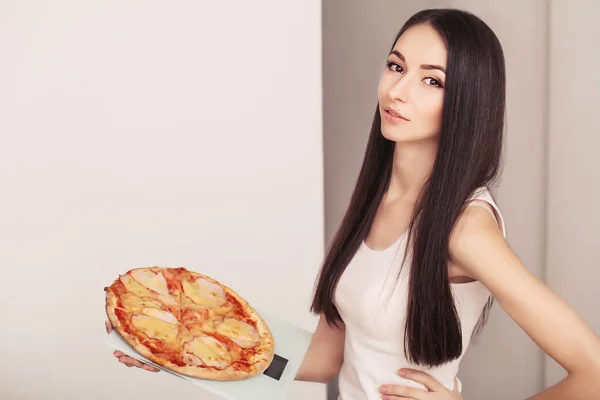 Diet And Fast Food Concept. Femme en surpoids debout sur l'échelle de pesée tenant la pizza. Malsaine malbouffe. Régime, mode de vie. Perte de poids. Obésité — Photo