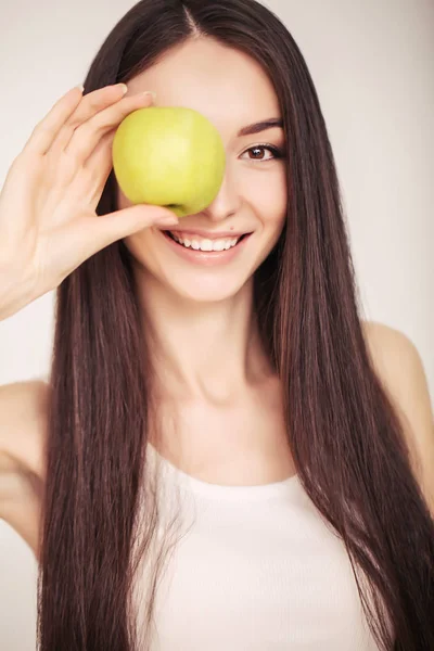 Dieta. Uma jovem observa sua figura e come frutas frescas. O conceito de alimentação saudável . — Fotografia de Stock