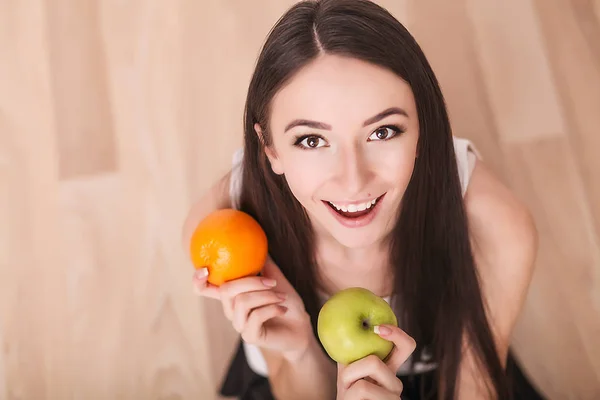 Dieta. Uma jovem observa sua figura e come frutas frescas. O conceito de alimentação saudável . — Fotografia de Stock