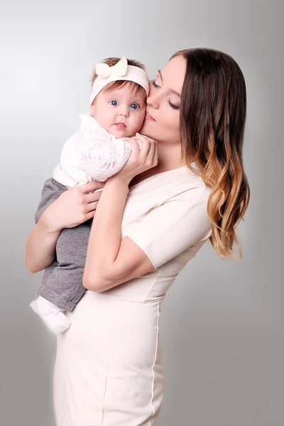 Newborn baby in a tender embrace of mother at the window Stock Photo