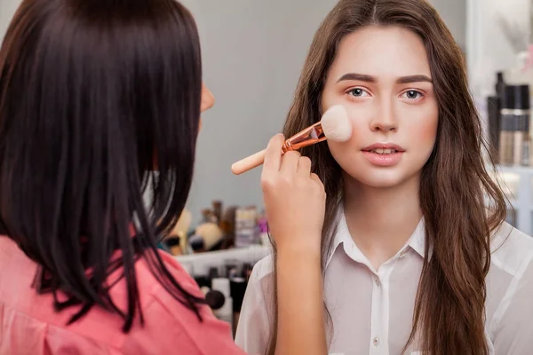 Schönheit, Make-up, Kosmetik und People-Konzept - Nahaufnahme eines lächelnden jungen Frauengesichts, das mit Make-up-Pinsel errötet — Stockfoto