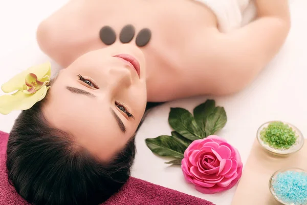 Persone, bellezza, spa, cosmetologia e concetto di cura della pelle - primo piano di bella giovane donna sdraiata con gli occhi chiusi e cosmetologo applicare la maschera facciale a pennello in spa — Foto Stock