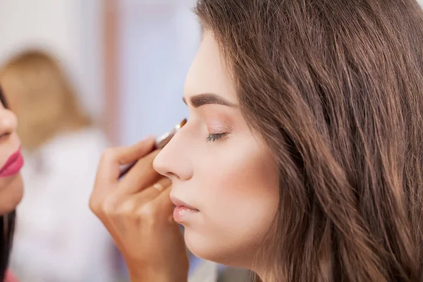 Joven, hermosa chica puesta en maquillaje en un salón de belleza — Foto de Stock