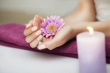 Spa çivi. Bakımlı tırnaklar. Güzel kız bir çiçek onun elinde tutar. Güzellik salonunda. Spa uygulamaları. Sağlık ve güzellik kavramı.