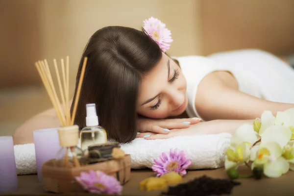 Woman at the spa. Healthy lifestyle and relaxation concept. A beautiful young woman on a massage table. Aroma oil and butter. Spa room.