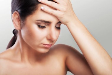 Kadın baş ağrısı. Zor bir iş günü sonra acı duygu kafamın içinde. Mygreen sağlık kavramı. Gri bir arka plan üzerinde.