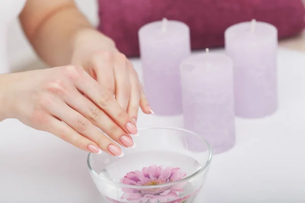 Mooie manicure met orchid, kaars en handdoek op de witte wo — Stockfoto