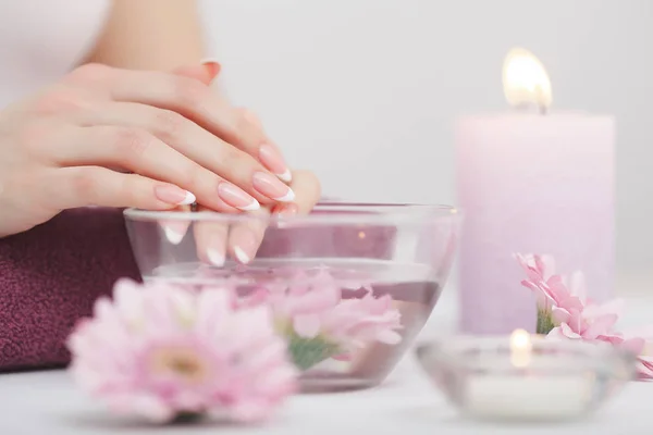 Mooie manicure met orchid, kaars en handdoek op de witte wo — Stockfoto