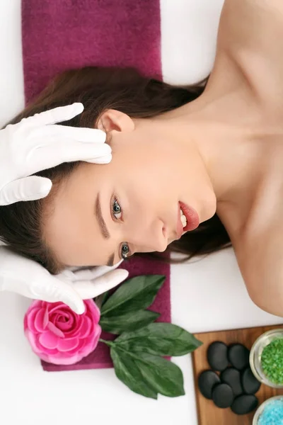 Красивая молодая женщина получает массаж лица в спа-салоне — стоковое фото