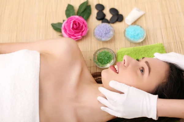 Belle jeune femme recevant un massage facial dans un salon de spa — Photo