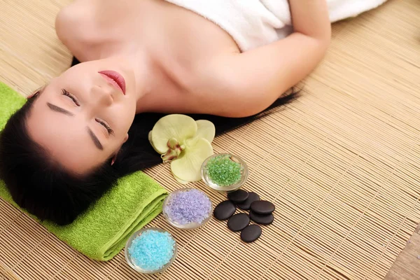 Cute relaxed young woman laying in spa salon with closed eyes — Stock Photo, Image