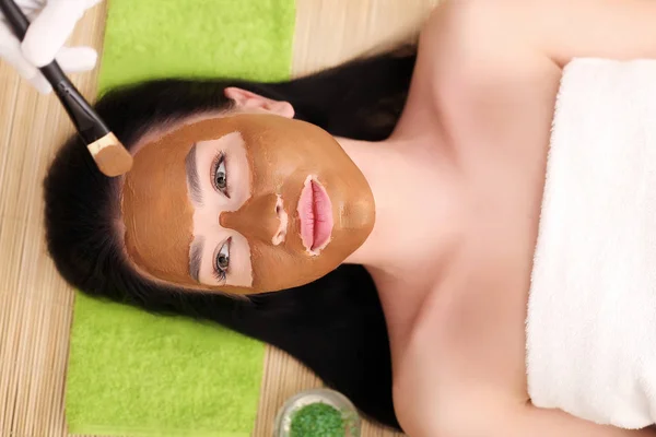 Spa massage för kvinna med ansiktsmask på ansikte — Stockfoto