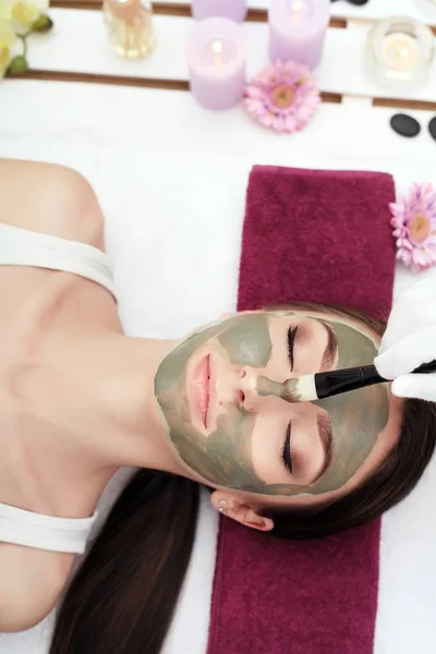 Tratamiento de belleza facial. Hermosa mujer consiguiendo máscara cosmética — Foto de Stock