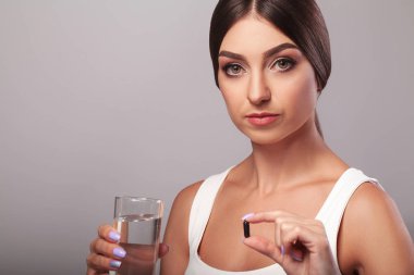 Soğuk algınlığı ve grip. Su ve alarak kapsül tutan kadın