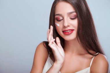 sağlıklı yüz kremi gözlerinin altında uygulanması ile mutlu bir kadın