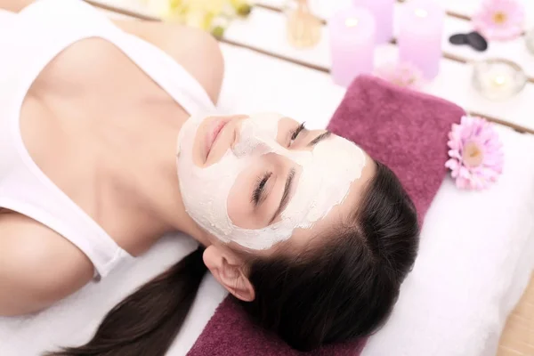 Menina com máscara facial deitada no centro de spa de beleza saúde — Fotografia de Stock