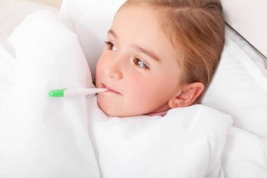 Hasta kız ateş meassuring sıcaklık ile yatakta dinleniyor