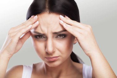 Bir gri arka plan, stres ve baş ağrısı migren baş ağrısı ile güzel bir kadın, o çekişti ağrı, büyük portre, kaliteli, profesyonel makyaj ile.