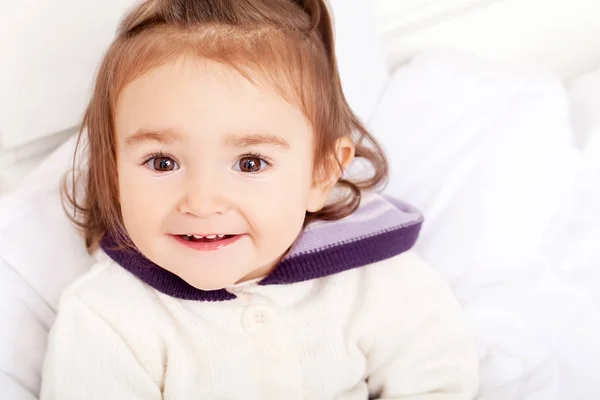 Portret van het meisje van de baby liggend in bed onder featherbed — Stockfoto