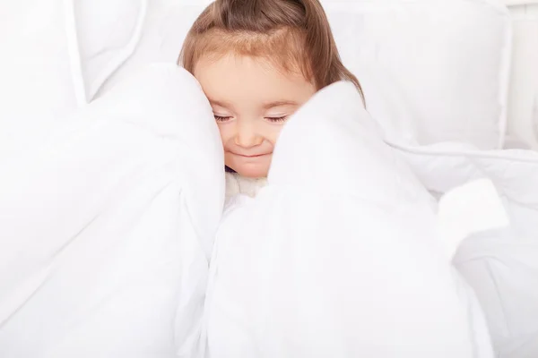 Portret dziewczynka leżąc w łóżku pod Pierzyna — Zdjęcie stockowe