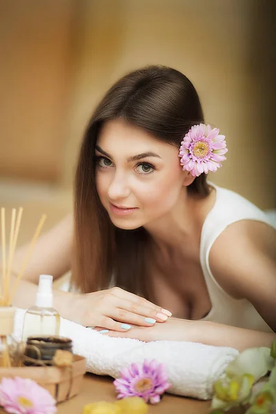 Porträt einer schönen Frau. Hautpflege. Wellness-Behandlungen. Blume im Haar. das Konzept von Schönheit und Gesundheit. im Massagesalon. — Stockfoto