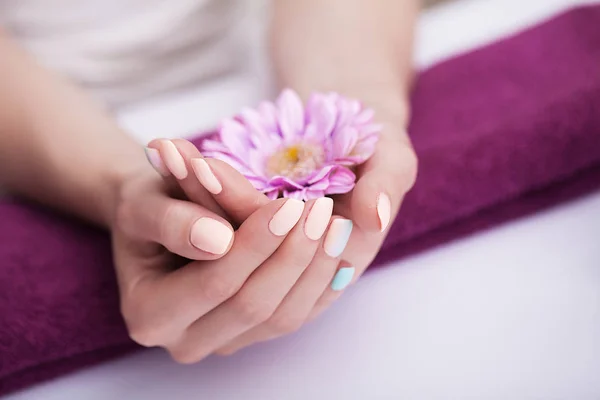 Unhas no spa. Bela manicura. Tratamentos de spa para mãos e unhas. Ensopando as mãos no lenço. Flores O conceito de spa e beleza . — Fotografia de Stock