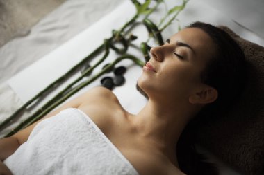 Güzel genç bir kadın güzellik salonunda yüz bakımı yaptırıyor..