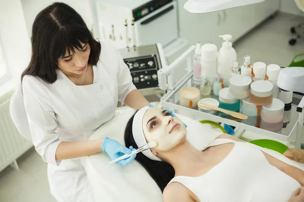 美容师在 cosmeto 的客户中应用面霜 — 图库照片