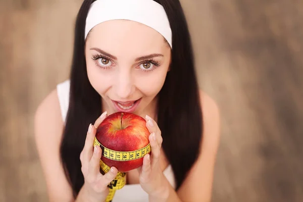 Joven mujer bastante sonriente de pie sosteniendo manzana roja.Concepto de comida saludable —  Fotos de Stock