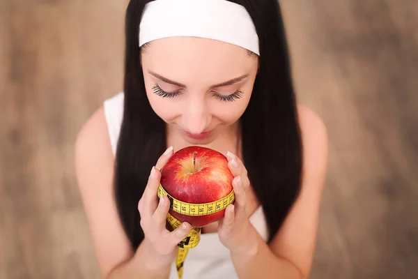 Jeune jolie femme tient pomme et ruban à mesurer. Concept d'alimentation saine . — Photo