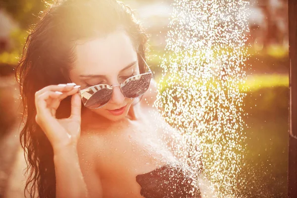 Hübsche Frau unter der Dusche am Strand an sonnigen Tag — Stockfoto