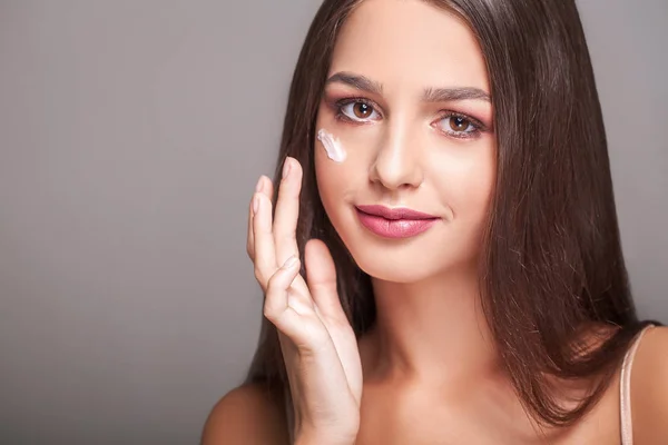 Cuidado de la piel de belleza. Hermosa mujer feliz aplicando crema cosmética — Foto de Stock