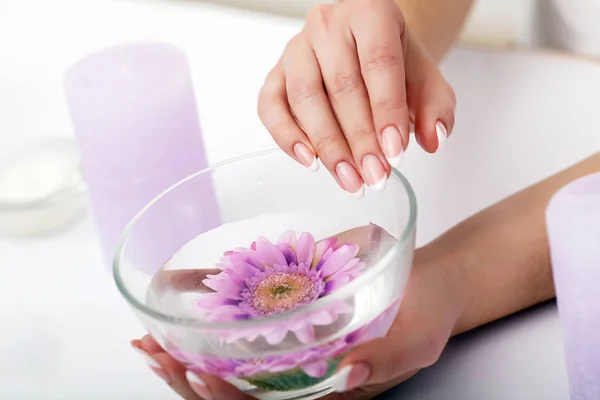 Woman hands in a nail salon receiving a hand scrub peeling by a