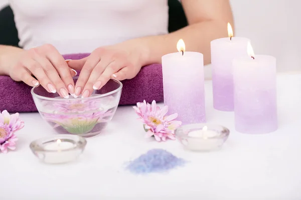 Closeup shot of a woman in a nail salon receiving a manicure by