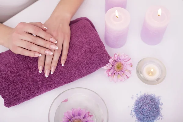 Woman hands in a nail salon receiving a hand scrub peeling by a