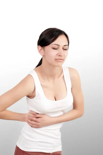 Pain. Woman hand holding abdominal with stomach ache lying on be — Stock Photo, Image